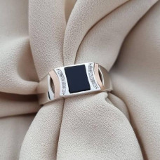 Silver signet ring with gold soldering and a black rectangular stone and zircons